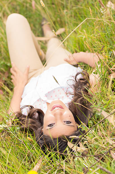 istock Beautiful young woman lying on green grass 505281077