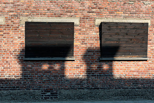 City street lights at night shine across the bricks of an urban apartment building