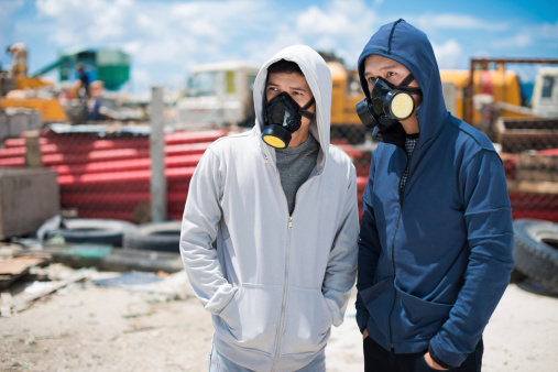 Portrait of two young people in respirators standing outdoors