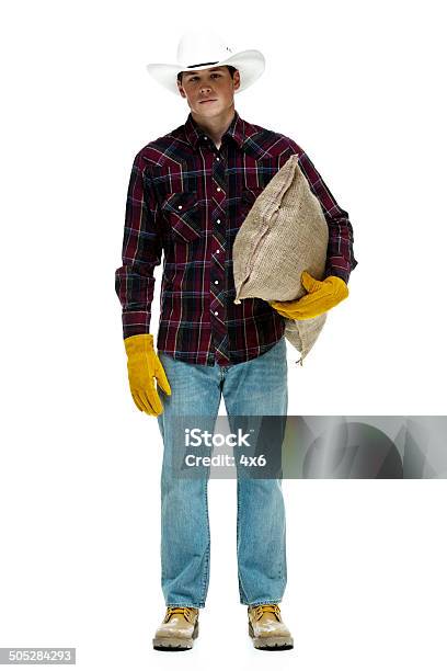 Farmer Holding Burlap Sack Looking At Camera Stock Photo - Download Image Now - 20-29 Years, Adult, Adults Only