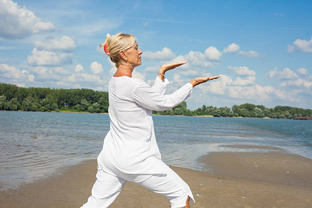 Woman in white clothes doing tai chi stock photo