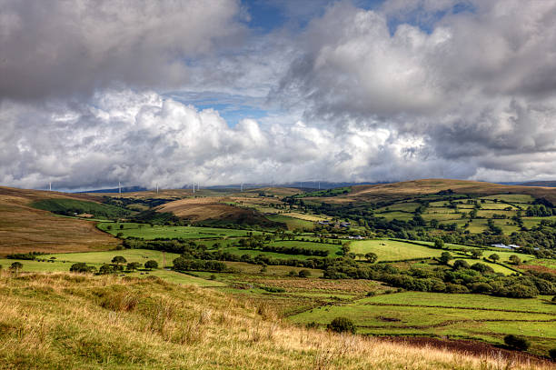 istock Welsh farmland with wind turbines on horizon 505284731