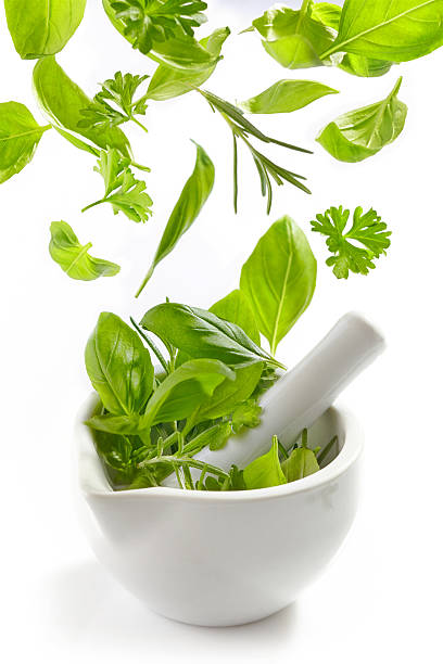 istock green herbs falling into mortar and pestle 505285997