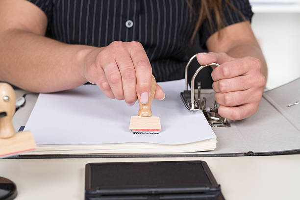istock Woman is stamping a document with a stamp 505287341