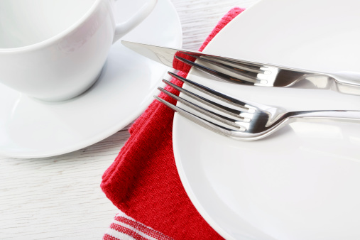 Empty coffee cup and plate on red napkins