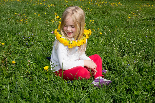 istock girl in a wreath from dandelions smiling 505288215