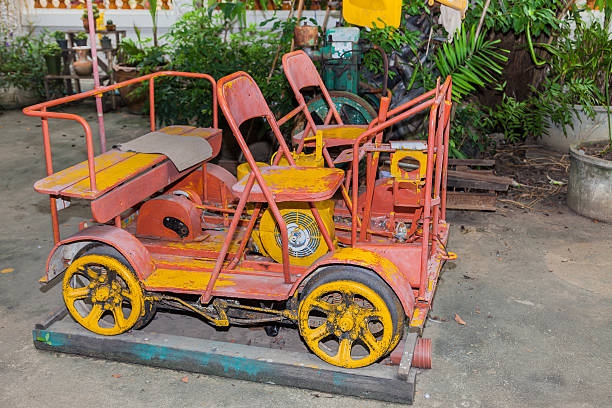 A rustic wooden cart surrounded by vibrant potted plants adorns the charming streets of Vigan City, Philippines, reflecting a blend of history and natural beauty under sunny skies.