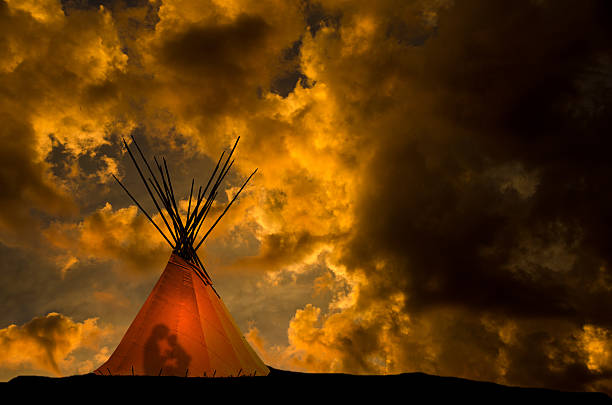 istock Teepee and gold sunset- light and people in the teepee 505293462