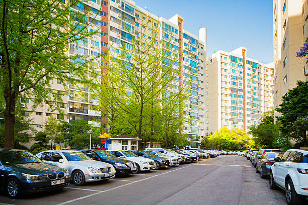 Row of Gangnam apartment buildings with luxury cars Seoul, South Korea - April 25, 2015: Row of Gangnam apartment buildings with luxury cars parked in front. New leaves are growing on the trees. kangnamgu stock pictures, royalty-free photos & images