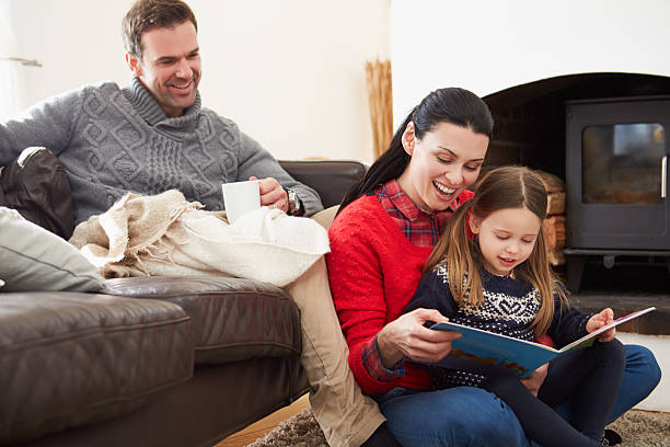 istock Family Relaxing Indoors And Reading Book 505302381