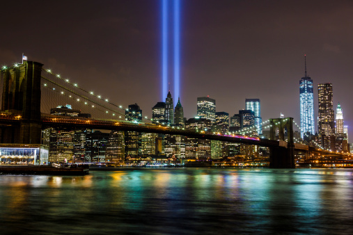 Brooklyn Bridge and Manhattan skyline with The Tribute in Light at night on September 11, 2013. The Tribute in Light is an art installation of 88 searchlights creating two columns of light in memory of the September 11th attacks.