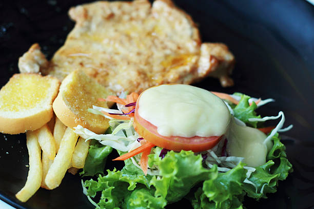 istock Pork steak with vegetable salad on plate. 505305009