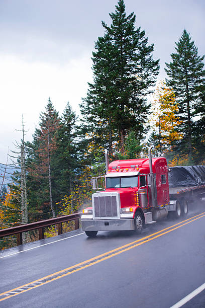 istock Bright red semi truck big rig classic style on rain 505329844
