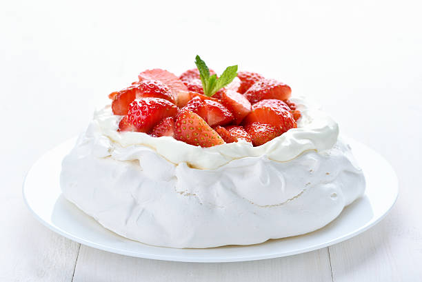 Meringue cake with fresh strawberry Meringue cake with fresh strawberry on white wooden background, close up view pavlova stock pictures, royalty-free photos & images