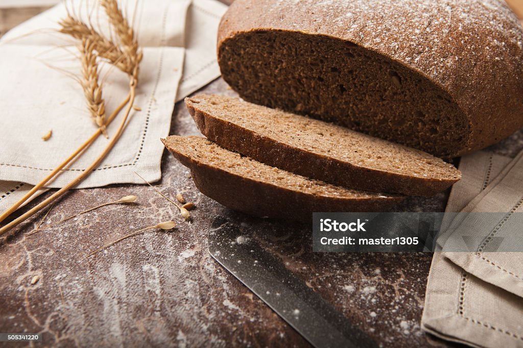 Bread rye spikelets on an wooden background Bread rye spikelets, napkins and knife on an wooden background African Ethnicity Stock Photo