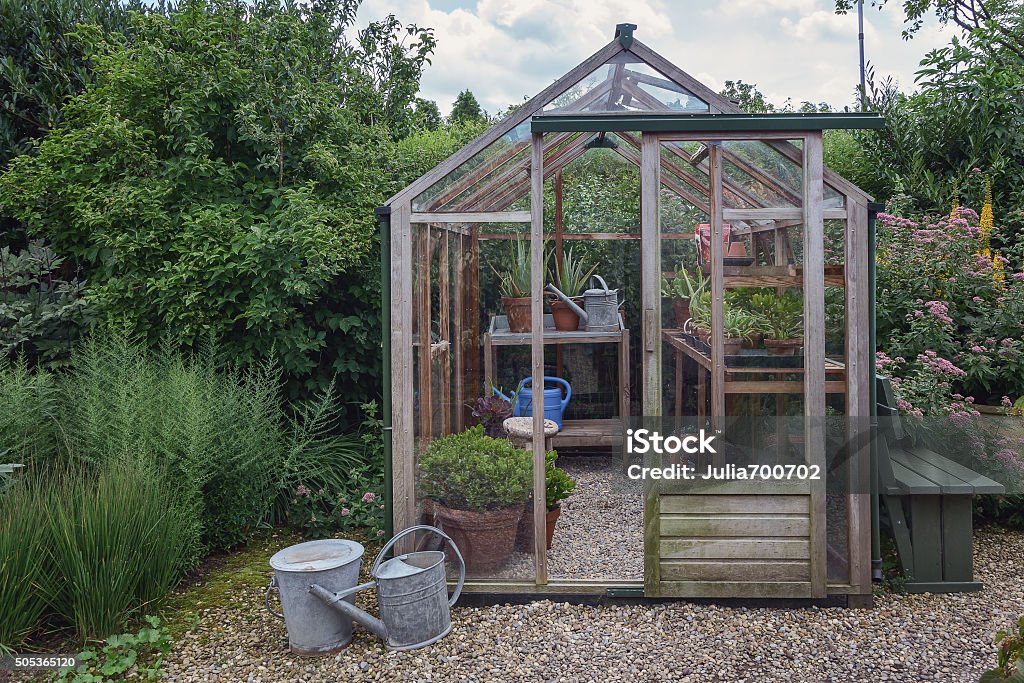 Little greenhouse in the garden. Little greenhouse on the territory of the garden. Greenhouse Stock Photo