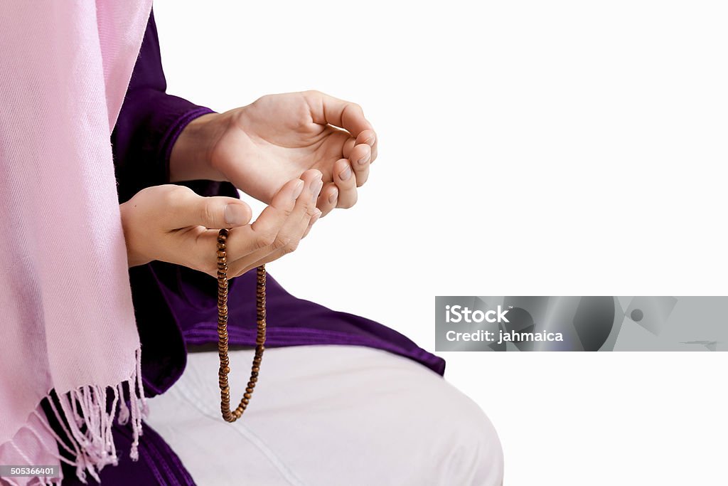 Young muslim girl praying Young muslim girl with prayer beads praying on white background Adult Stock Photo