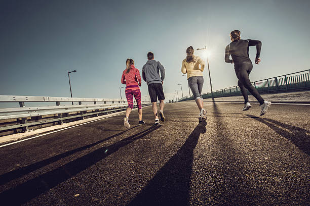 istock Rear view of young people running on a bridge. 505368136