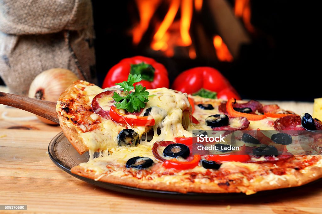tasty pizza Pizza lifting slice with pepperoni and olives Pizza Stock Photo