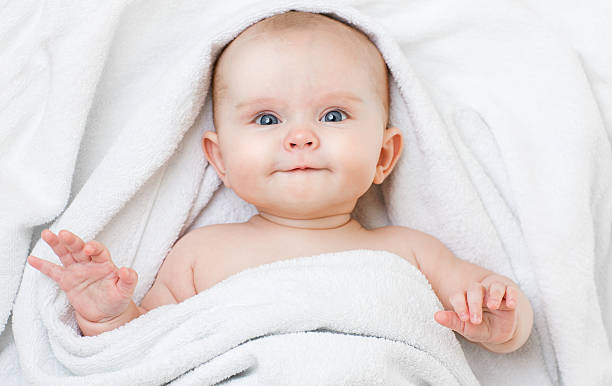 istock Cute funny smiling baby lying on back in bathing towel 505371028