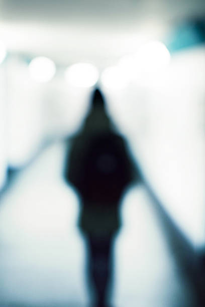 Defocused woman walks into the bright tunnel subway