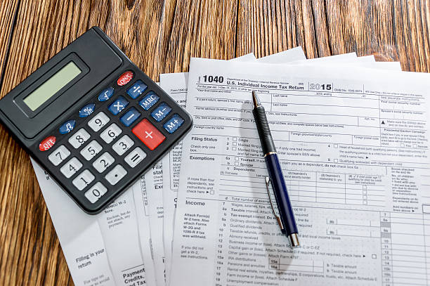 istock Tax form 1040 with pen and calculator on the table 505374170