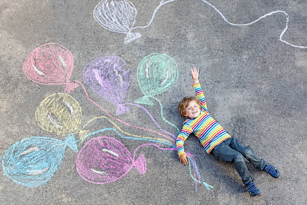 los niños niño divirtiéndose con coloridos globos con chalks dibujo - child balloon outdoors little boys fotografías e imágenes de stock