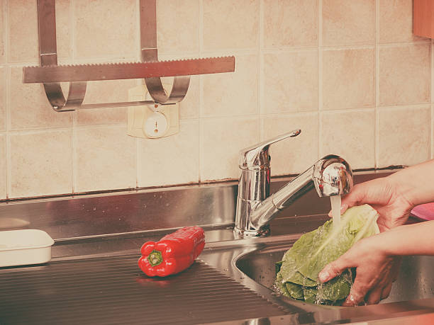 istock woman washing fresh vegetables in kitchen 505375992