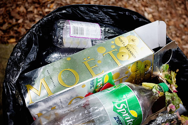 When the party's over: discarded Moet et Chandon champagne carton Natures Valley, South Africa - January 10, 2016:  Nature's Valley, South Africa  After a party, a box that held a bottle of Moet & Chandon champagne lies discarded with other rubbish in a trash can. Close up. moet chandon stock pictures, royalty-free photos & images