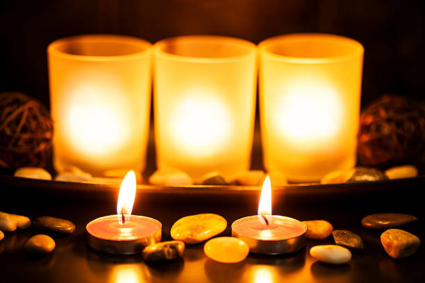 istock candles glowing in a glass jar 505379470