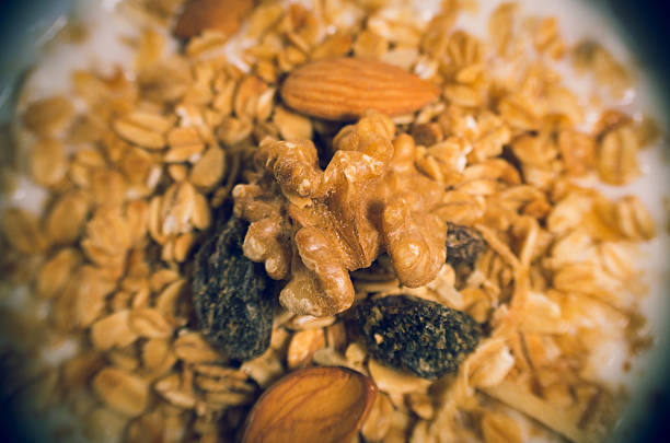 Closeup white youghurt with granola, almonds and raisins on top
