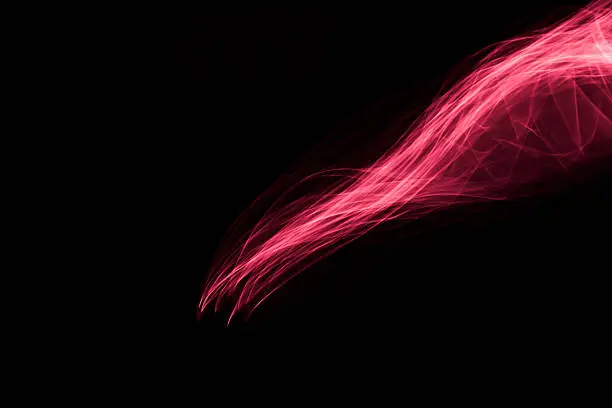 Photo of Glowing abstract curved light red and pink lines