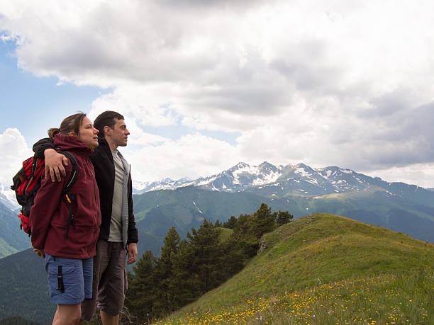istock Man embraces a woman standing on the grass 505393507