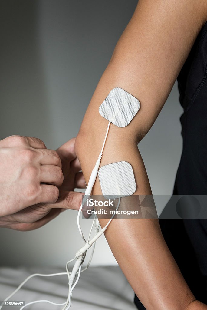 TENS Therapy Transcutaneous electrical nerve stimulation or TENS therapy on elbow Electrode Stock Photo