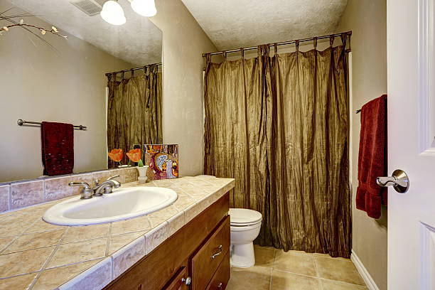 istock Bathroom with brown cabinet and mustard curtains 505398601