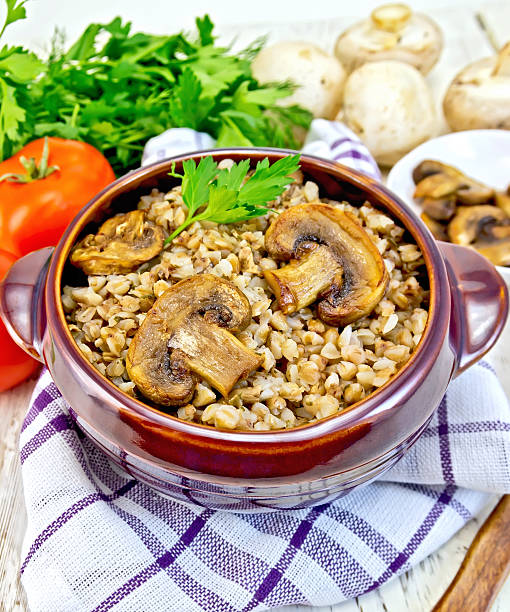 istock Buckwheat with champignons in clay bowl on light board 505398620