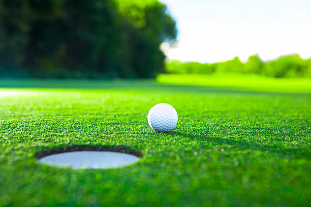 Concepts Golf ball on the lawn hole stock pictures, royalty-free photos & images