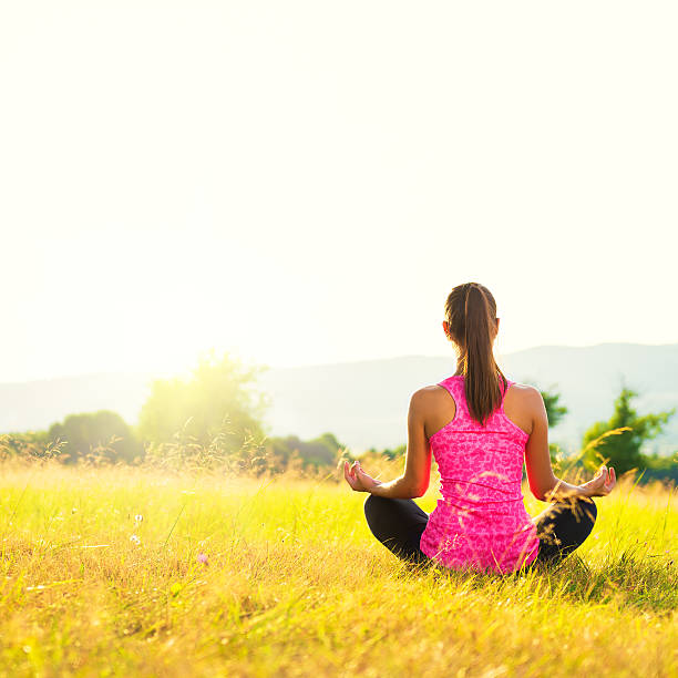 istock Young athletic woman practicing yoga on a meadow at sunset 505399712
