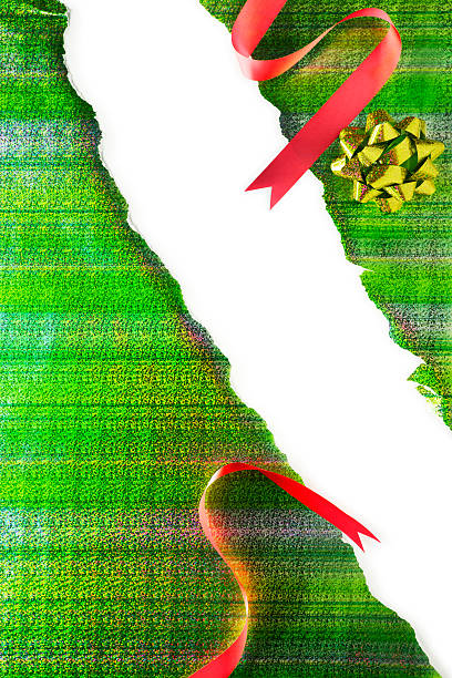This is a photo of green wrapping paper and red bow ripped open. There is a lot of space for copy in the middle.