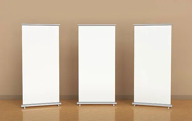 Blank roll-up banners against the brown wall