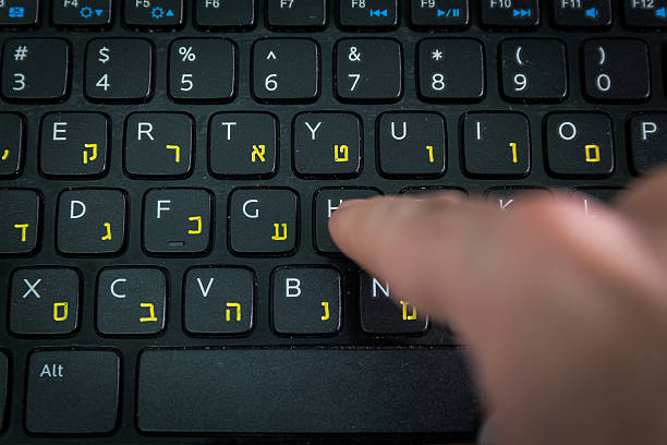 istock Man typing on keyboard with letters in Hebrew and English 505402638