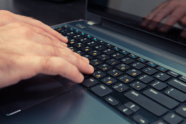 istock Man typing on keyboard with letters in Hebrew and English 505403664