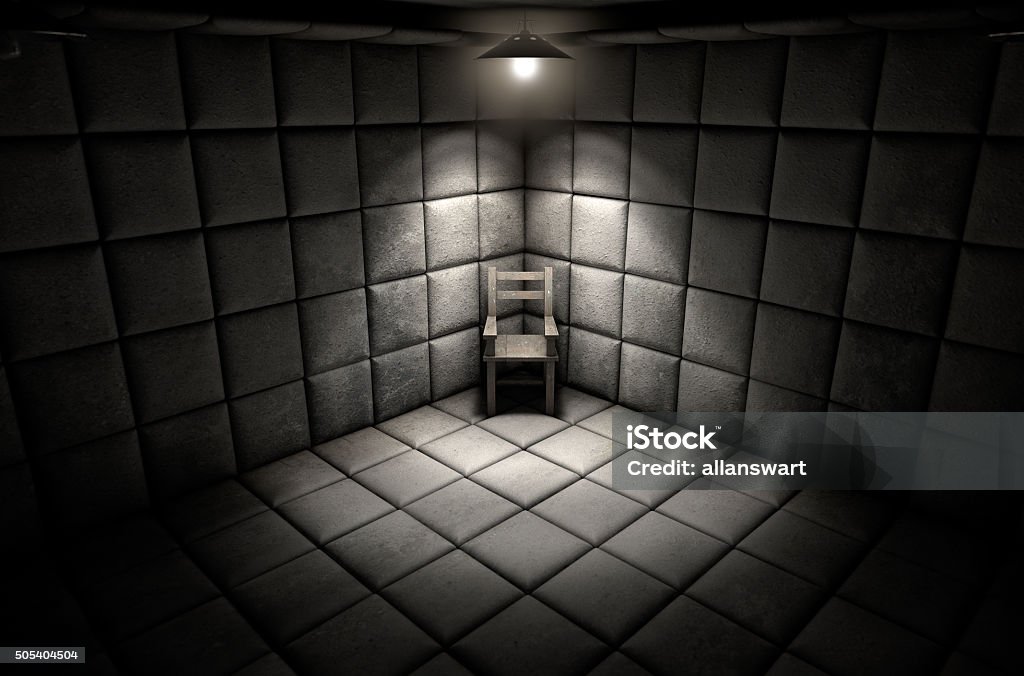 Padded Cell And Empty Chair A dark dirty white padded cell in a mental hospital with an empty chair in the corner lit by a single spotlight Bizarre Stock Photo