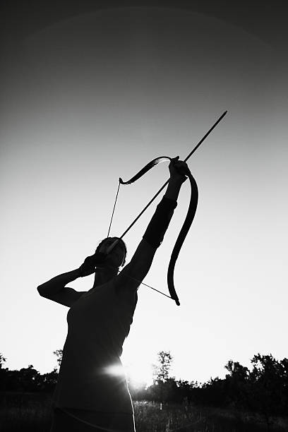 Female archer in the field at sunset