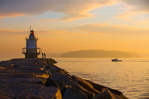 Spring Point Lighthouse at Dawn. Spring Point lighthouse, South Portland, Maine at dawn, as a lobster boat goes by. casco bay stock pictures, royalty-free photos & images