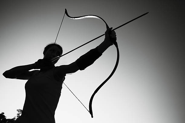 mujer en el campo de archer al atardecer - tiro con arco fotografías e imágenes de stock