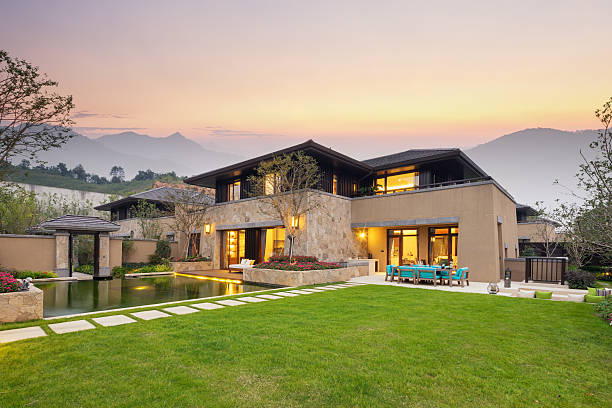 modern building by the fishpond and beautiful meadow in colorful sky at twilight