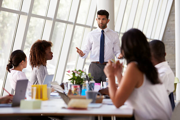 istock Hispanic Businessman Leading Meeting At Boardroom Table 505408192
