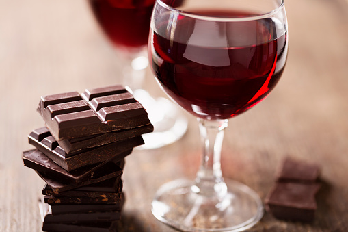 2 glaases with red wine and dark chocolate on wooden background, a wonderful combination