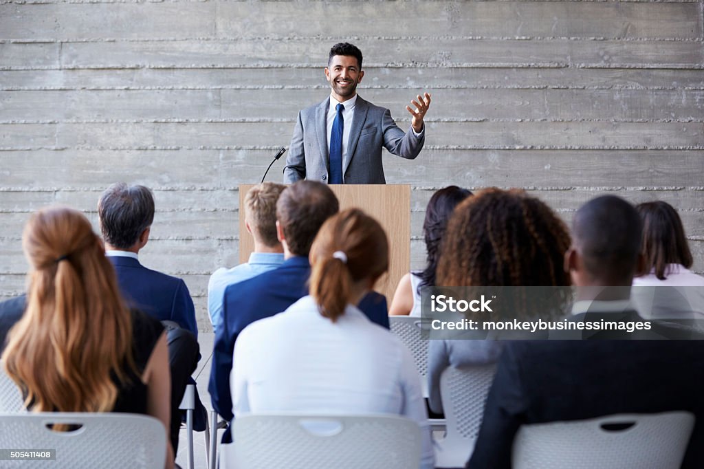Businessman Addressing Delegates At Conference Public Speaker Stock Photo